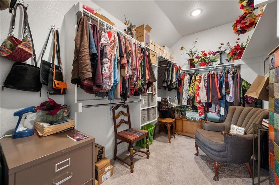 Spacious closet with vaulted ceiling and light carpet Spacious closet with vaulted ceiling and light carpet