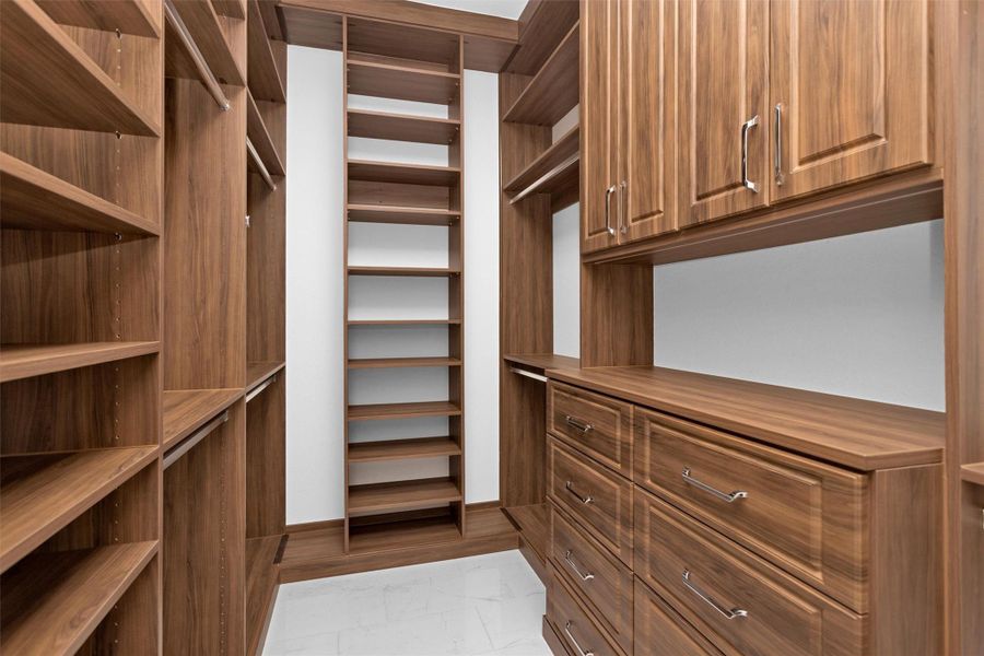 This second custom closet features rich wood built-ins, generous shelving, and sleek hardware—offering luxurious organization and storage for a truly elevated daily routine.