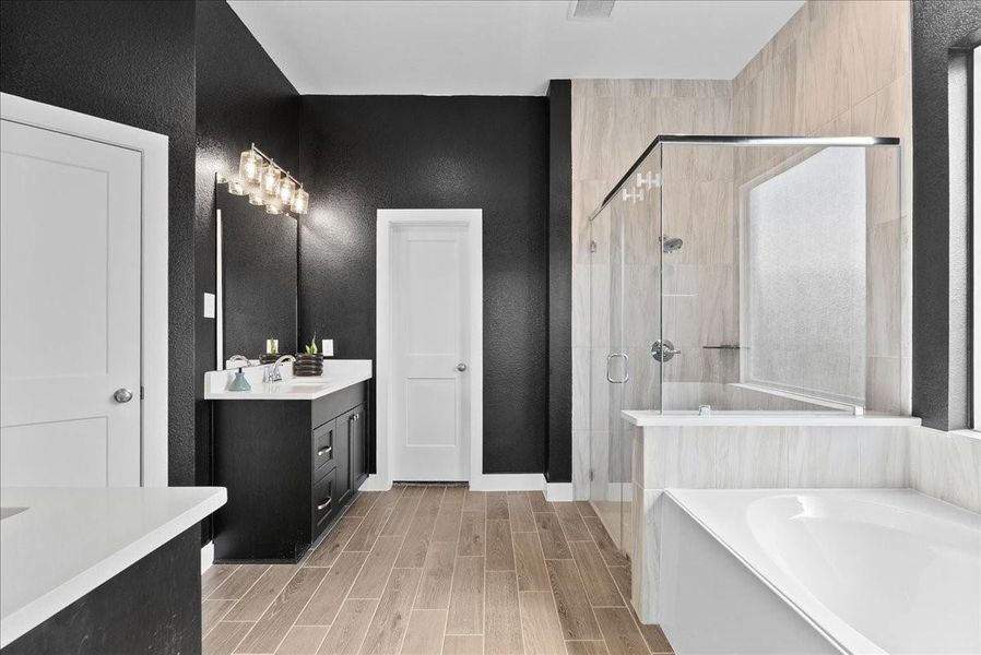 The spa-inspired en suite showcases bold black walls, sleek floor-to-ceiling tile, and a modern glass-enclosed shower creating a dramatic yet sophisticated retreat. The spa-inspired en suite showcases bold black walls, sleek floor-to-ceiling tile, and a modern glass-enclosed shower creating a dramatic yet sophisticated retreat.