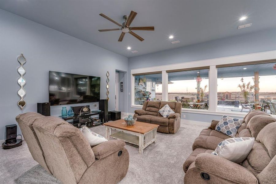 Carpeted living room with ceiling fan