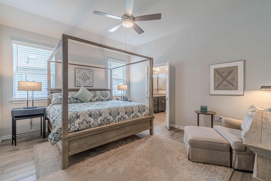 Bedroom featuring light wood-style floors, multiple windows, and baseboards