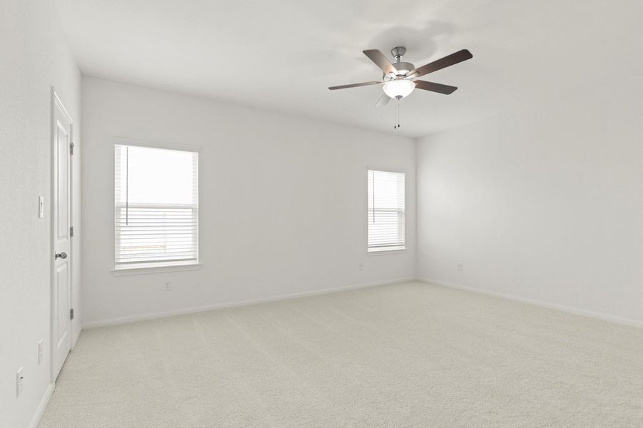 Empty room with light colored carpet and ceiling fan