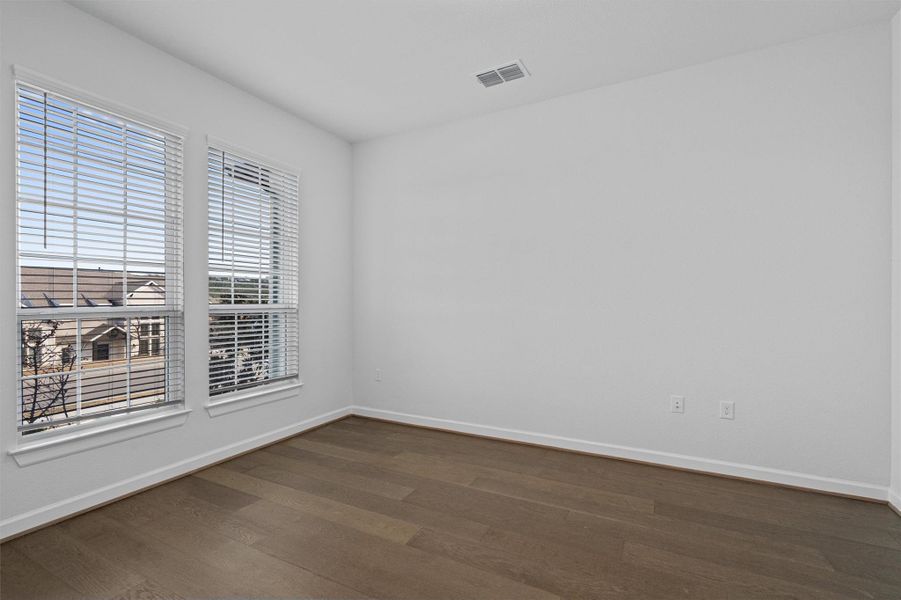 Unfurnished room with baseboards and dark wood finished floors Unfurnished room with baseboards and dark wood finished floors