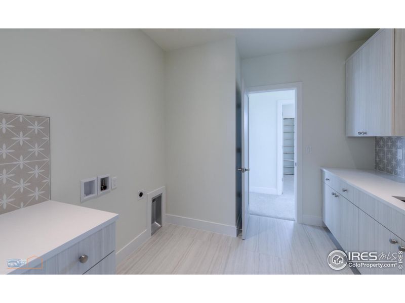 Second Floor Laundry Room With Built In Cabinetry, Laundry Sink And Dual Entry From Primary Bedroom And Hallway