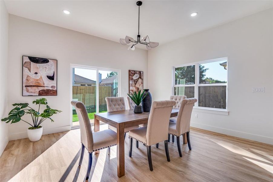 Dining area featuring light wood-type flooring, recessed lighting, and a chandelier Dining area featuring light wood-type flooring, recessed lighting, and a chandelier