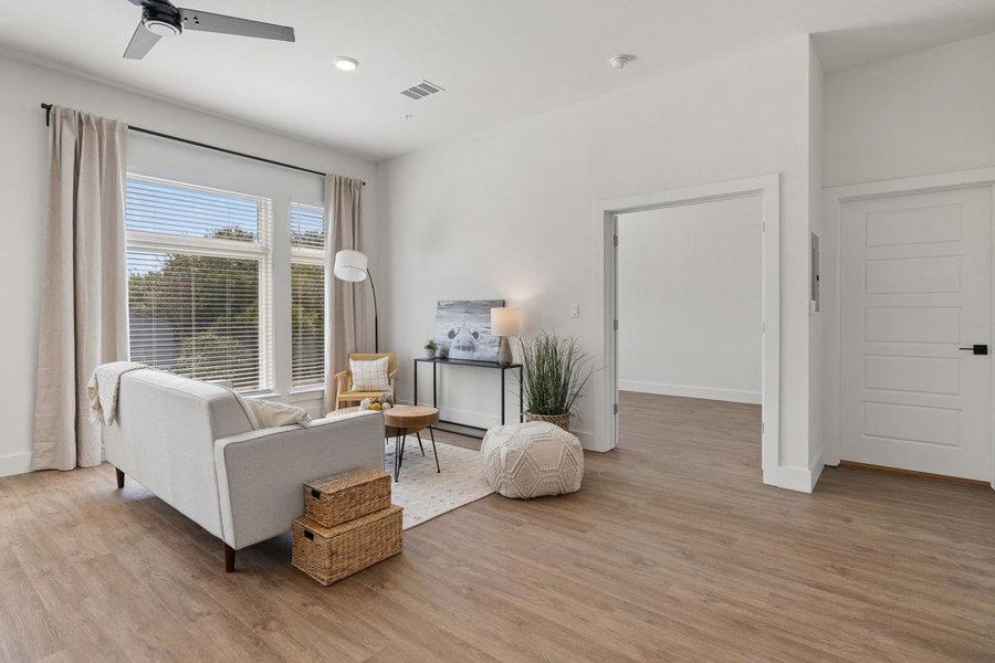 Living area with ceiling fan, light wood finished floors, and recessed lighting