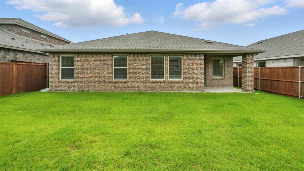 Rear view of house featuring a fenced backyard, brick siding, and a shingled roof Rear view of house featuring a fenced backyard, brick siding, and a shingled roof