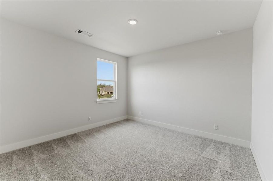 Empty room featuring light carpet and baseboards
