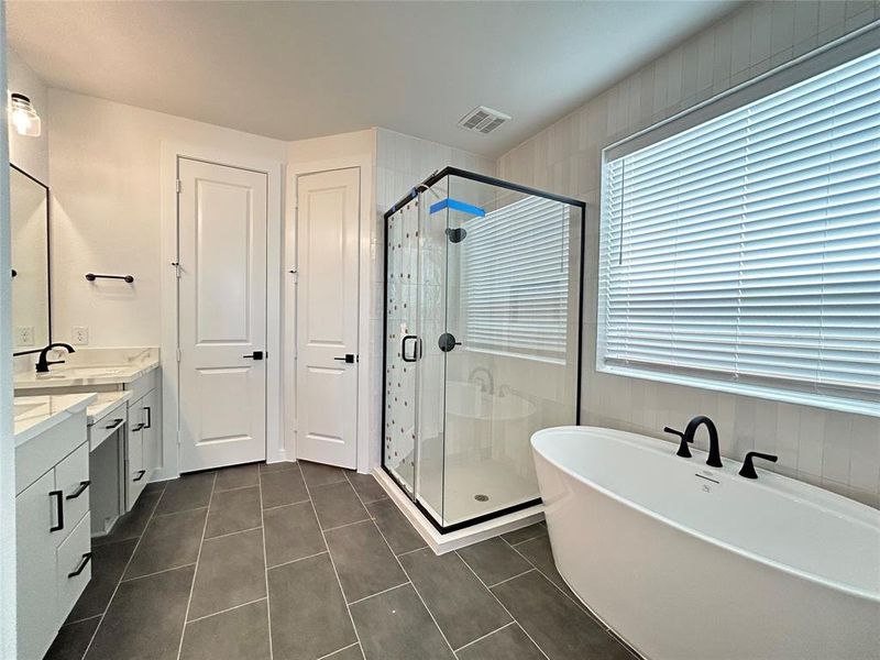 A sleek modern bathroom with clean lines and a freestanding tub as the focal point, surrounded by minimalist fixtures and soft ambient lighting. The design combines natural tones and smooth surfaces for a serene, spa-like atmosphere.