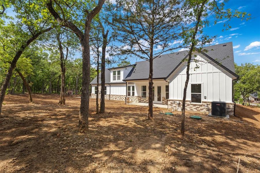 The property features a white exterior with board and batten siding, complemented by a stone foundation
