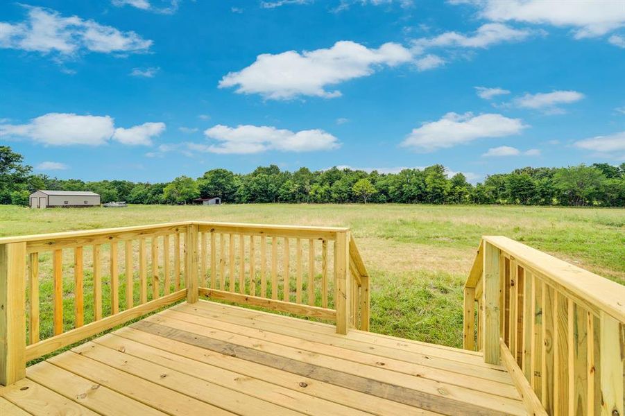 Expansive outdoor deck with a natural wood finish, featuring robust railings and steps