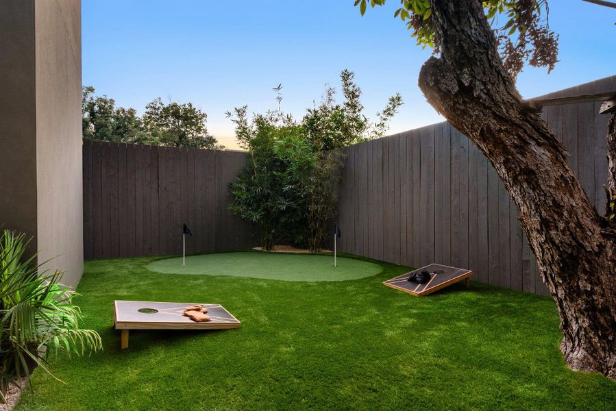 Fenced backyard with an area to practice putting Fenced backyard with an area to practice putting