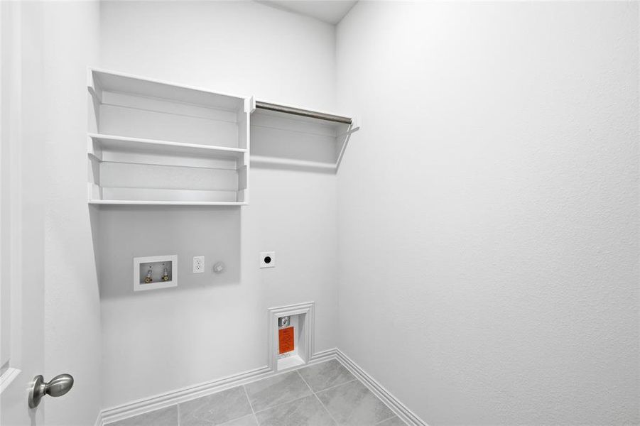 Washroom featuring electric dryer hookup, hookup for a gas dryer, washer hookup, and light tile patterned flooring