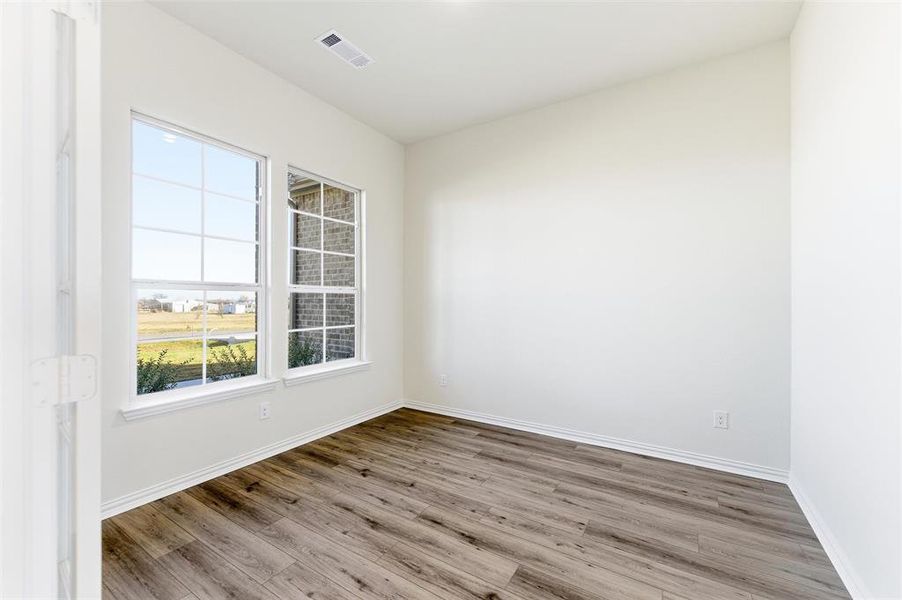 Unfurnished room with wood finished floors and baseboards