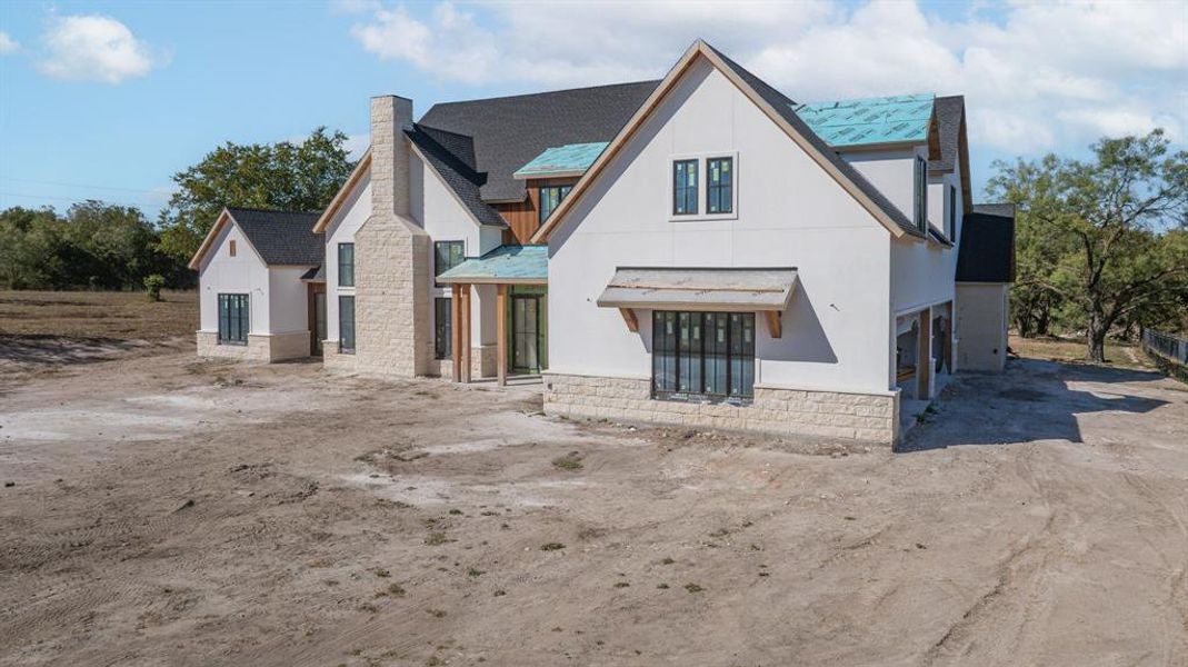 Rear view of house with a chimney and stone siding Rear view of house with a chimney and stone siding