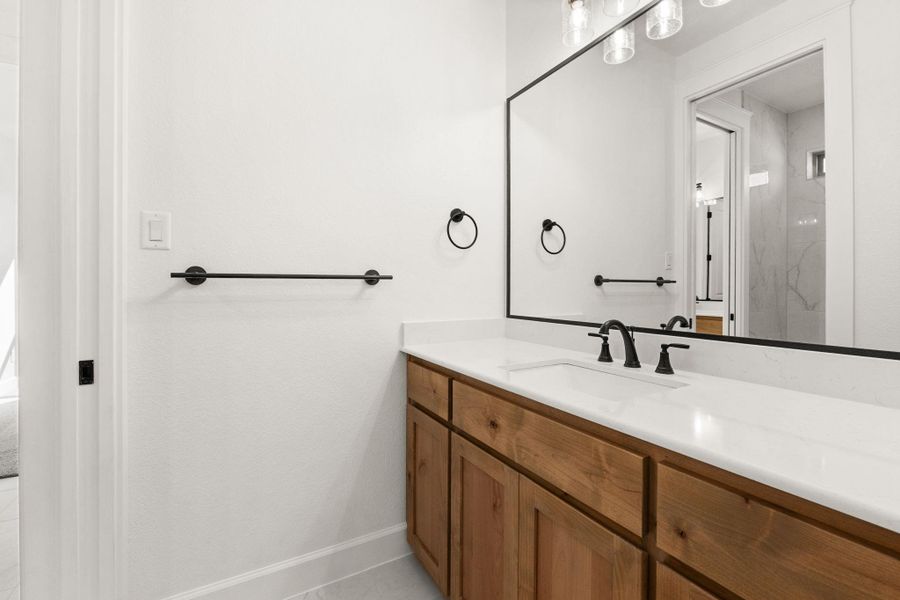 Full bath featuring vanity, light tile patterned floors, and a marble finish shower