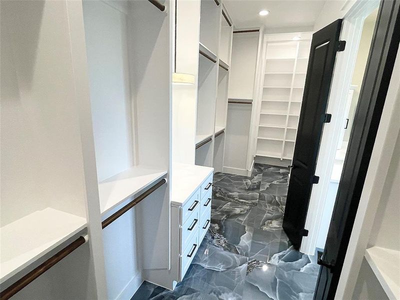 Over size master closet features expansive custom storage and built ins