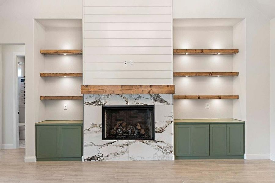 Unfurnished living room with light wood finished floors and a high end fireplace