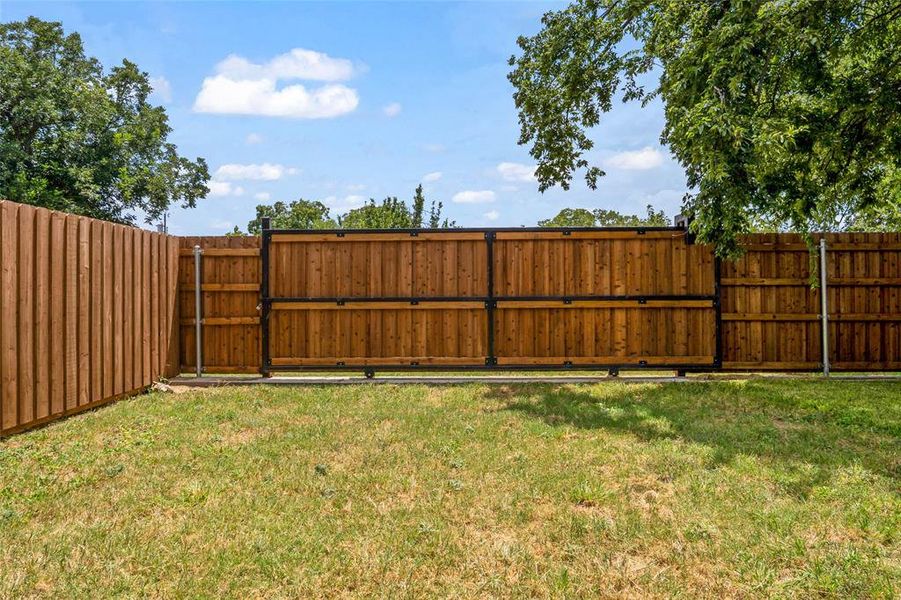 View of yard featuring a gate View of yard featuring a gate