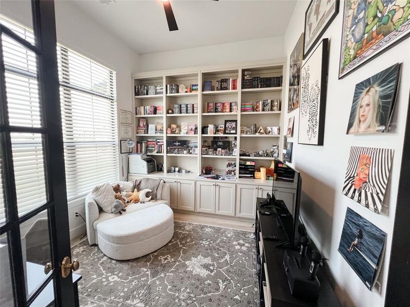 Sitting room with a ceiling fan and light wood-type flooring