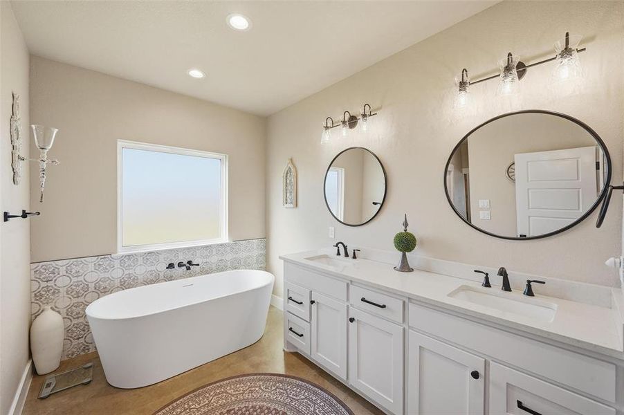 Primary Bathroom with a freestanding bath, double vanity, recessed lighting, and tile walls Primary Bathroom with a freestanding bath, double vanity, recessed lighting, and tile walls