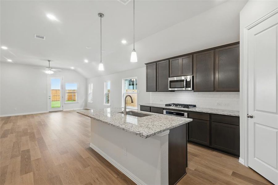 Kitchen featuring a sink, appliances with stainless steel finishes, lofted ceiling, decorative backsplash, and ceiling fan Kitchen featuring a sink, appliances with stainless steel finishes, lofted ceiling, decorative backsplash, and ceiling fan
