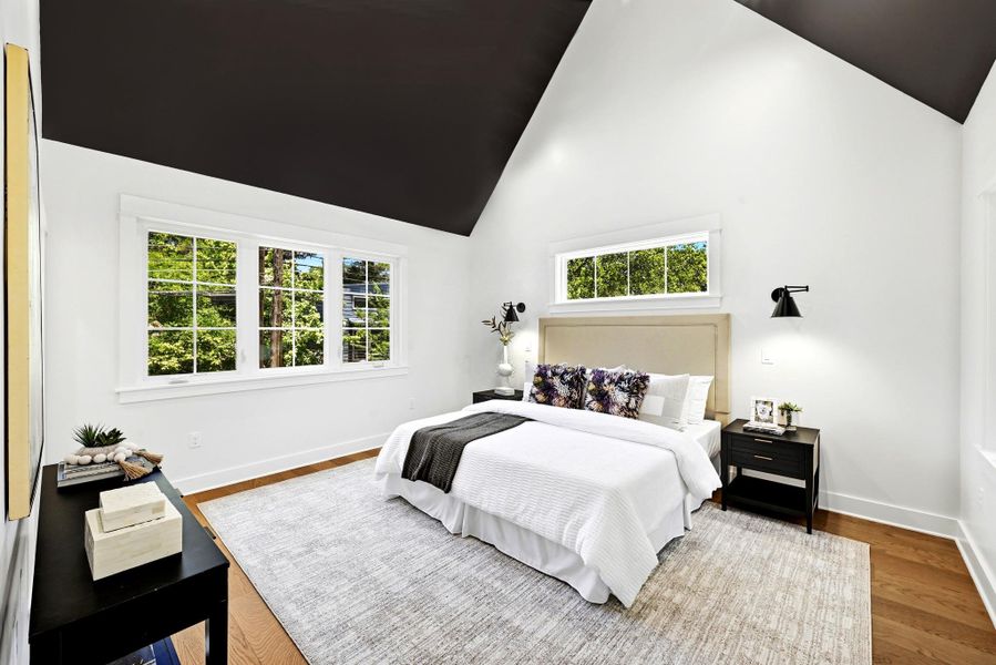 A tranquil bedroom with towering vaulted ceilings and natural hardwood flooring. A tranquil bedroom with towering vaulted ceilings and natural hardwood flooring.