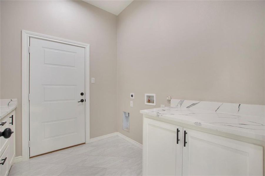 Washroom with cabinet space, washer hookup, electric dryer hookup, and gas dryer hookup Washroom with cabinet space, washer hookup, electric dryer hookup, and gas dryer hookup