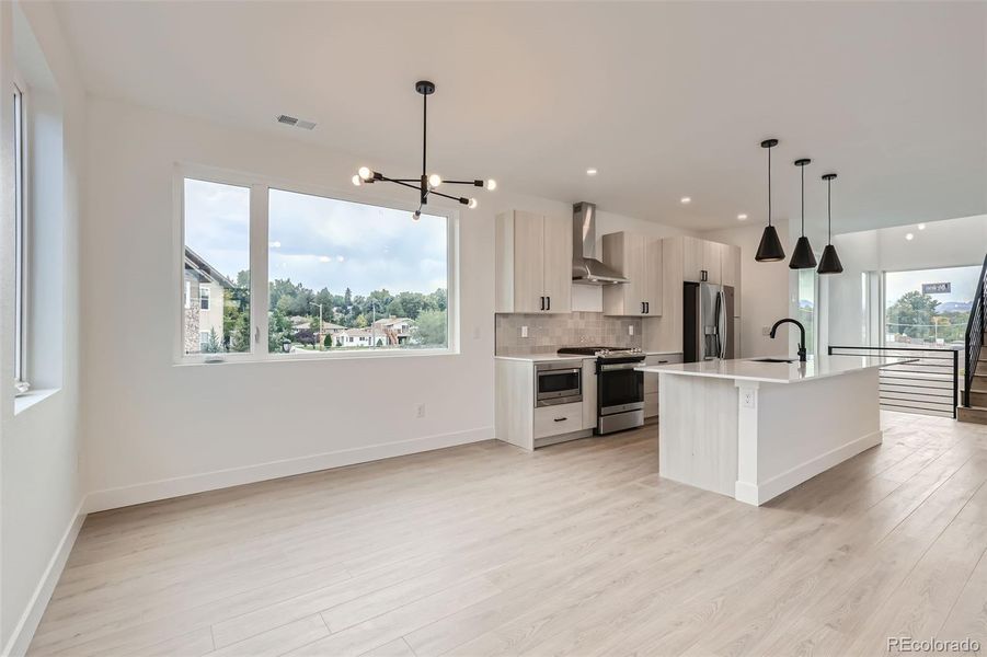 Dining room with designer chandelier opens to kitchen and living room.