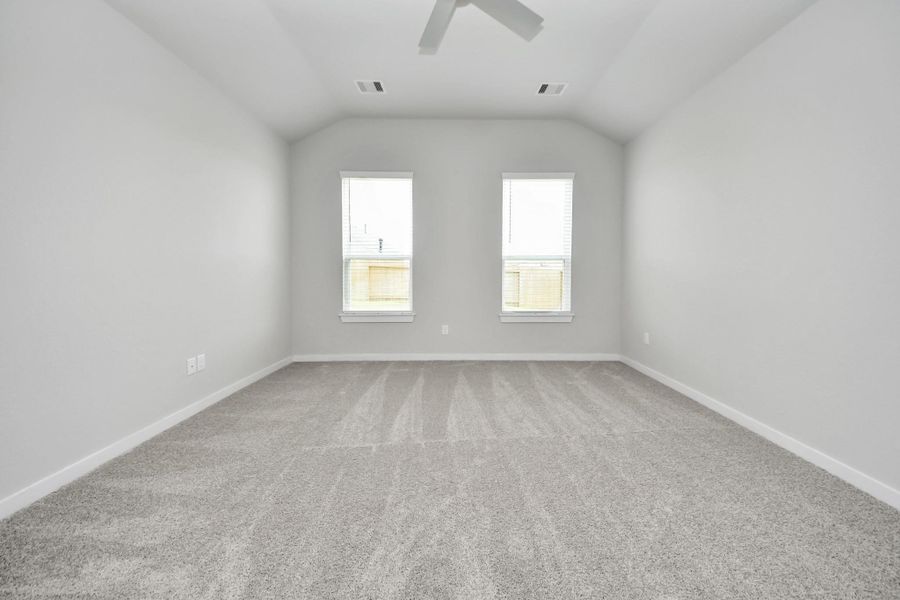 Retreat to the luxurious primary suite, your perfect escape for unwinding after a long day. Located on the first floor, this spacious room features plush carpeting, calming paint tones, high ceilings, and large windows with privacy blinds. Sample photo of completed home with similar floor plan. Actual colors and selections may vary. Retreat to the luxurious primary suite, your perfect escape for unwinding after a long day. Located on the first floor, this spacious room features plush carpeting, calming paint tones, high ceilings, and large windows with privacy blinds. Sample photo of completed home with similar floor plan. Actual colors and selections may vary.