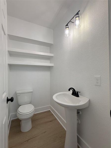 Half bath on the first floor with built-in shelves, adding a chic touch.