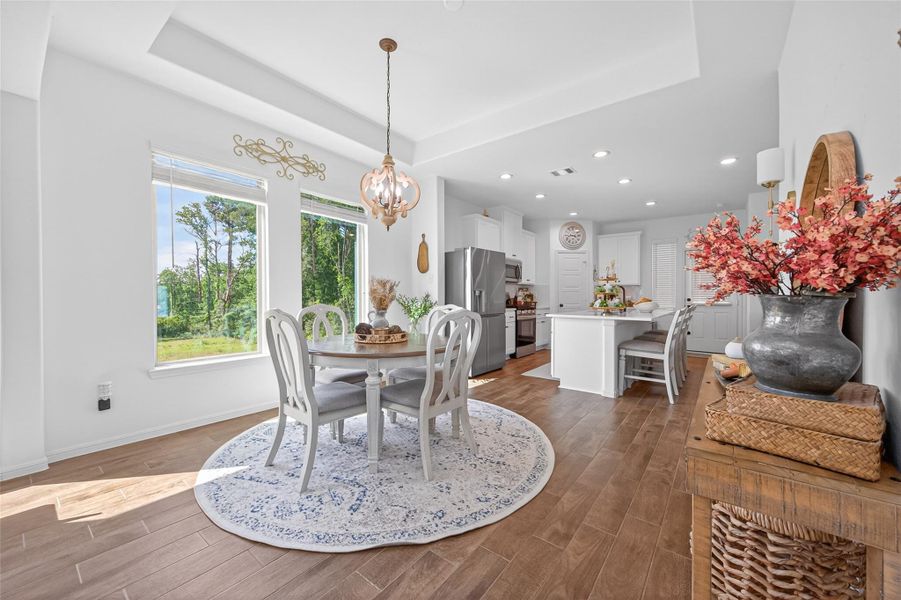 Bright and inviting dining area with custom fixed picture windows showcasing a lush outdoor view. Bright and inviting dining area with custom fixed picture windows showcasing a lush outdoor view.