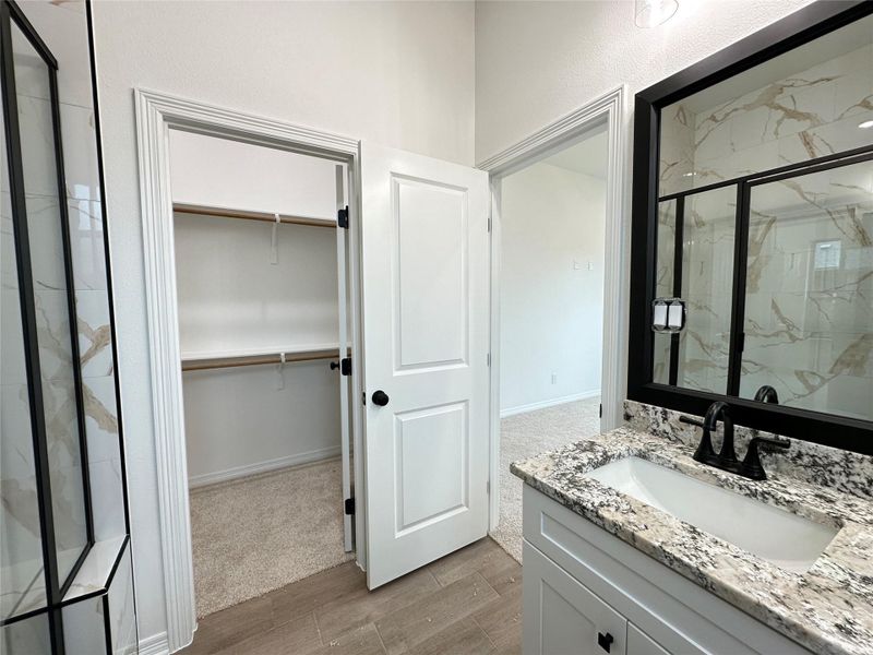 Bathroom featuring a white vanity with a granite countertop, undermount sink, and matte black faucet
