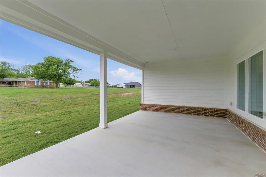The property features a spacious covered patio with a concrete floor, white columns, and a white ceiling