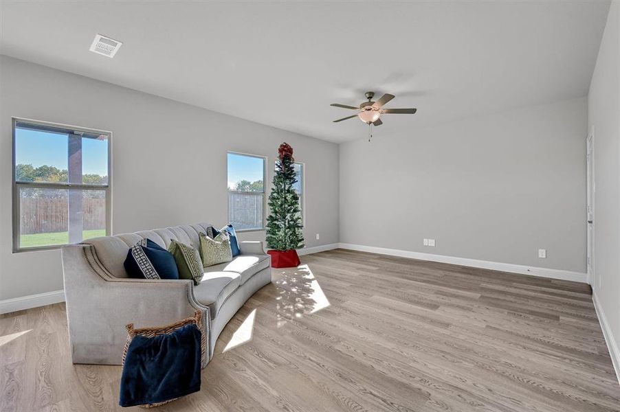 Living room with light hardwood / wood-style floors and ceiling fan