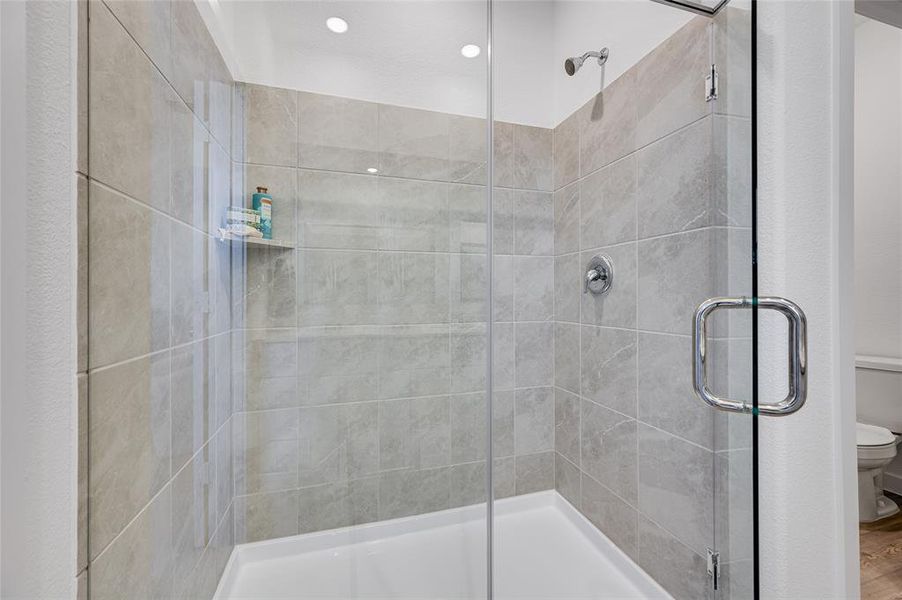 Bathroom with a shower with door and toilet