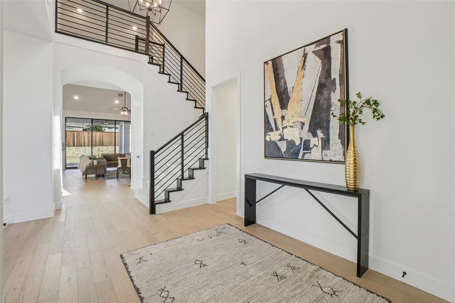 Entryway with a high ceiling, arched walkways, stairway, light wood-type flooring, and recessed lighting Entryway with a high ceiling, arched walkways, stairway, light wood-type flooring, and recessed lighting