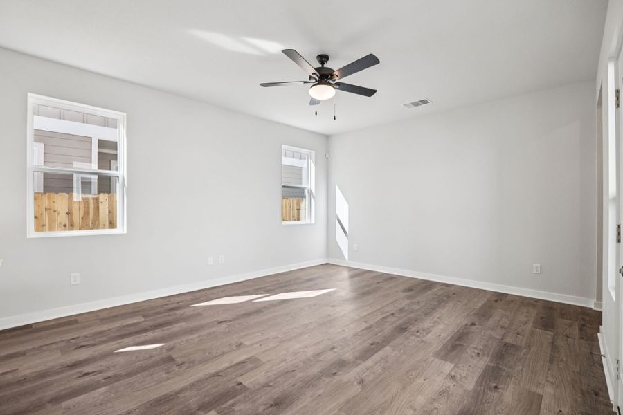 A room with a wood floor and a ceiling fan.