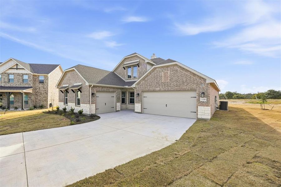 Craftsman inspired home with a front yard, brick siding, driveway, an attached garage, and a shingled roof