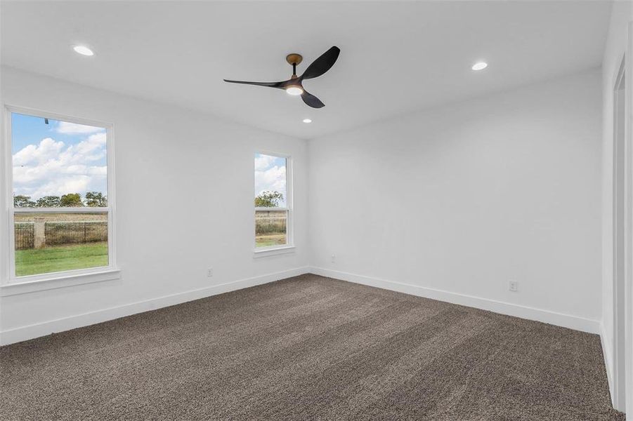 Empty room with dark colored carpet, recessed lighting, and a ceiling fan Empty room with dark colored carpet, recessed lighting, and a ceiling fan