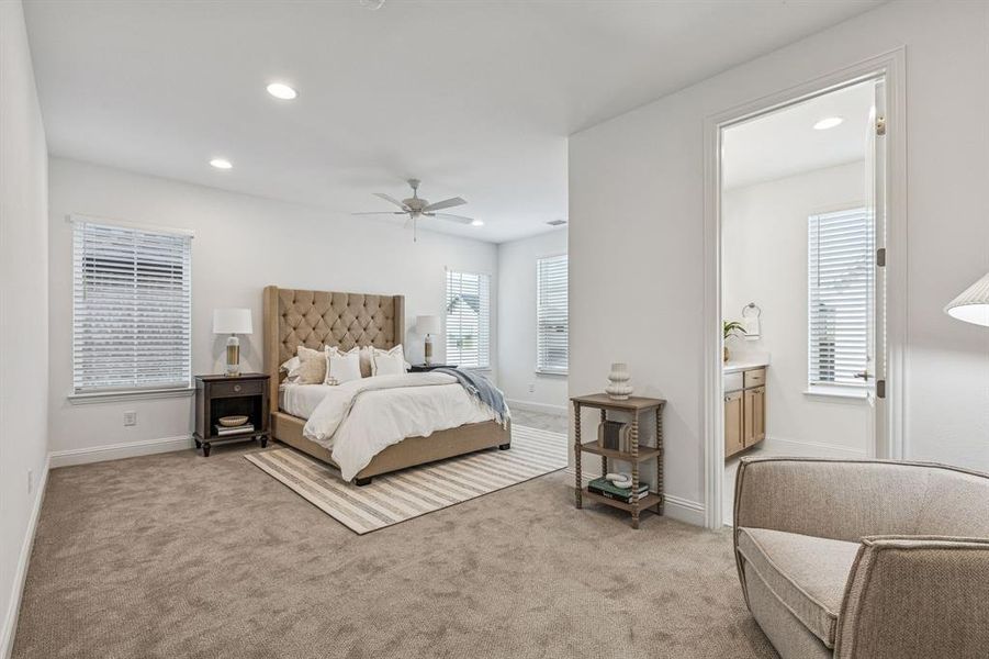 Bedroom with ceiling fan, light colored carpet, ensuite bathroom, and recessed lighting