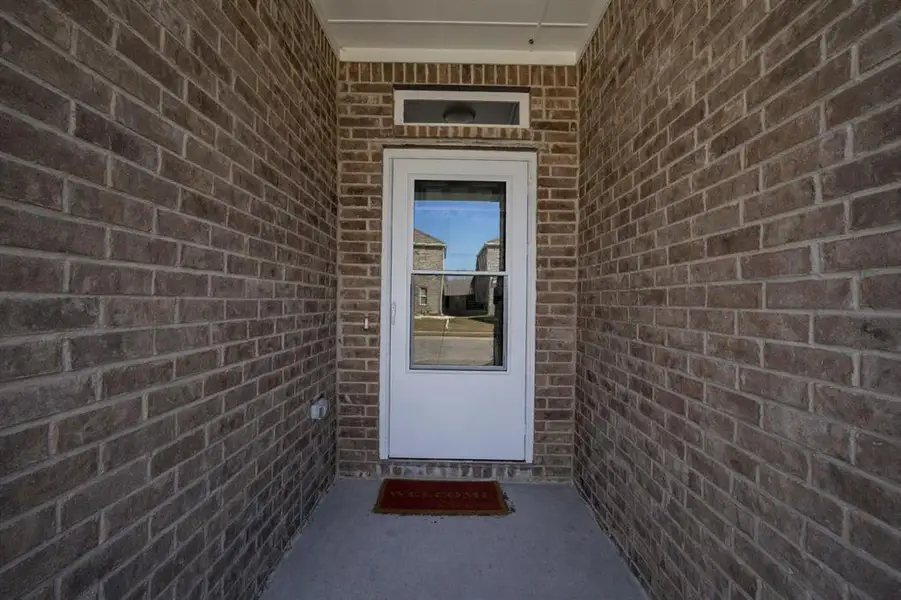 View of exterior entry with brick siding
