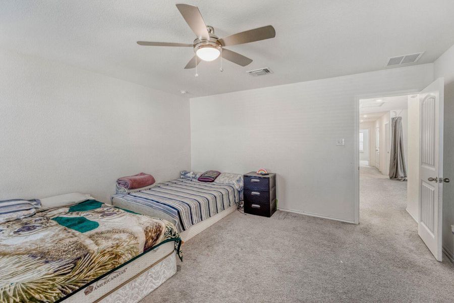 Carpeted bedroom featuring a ceiling fan