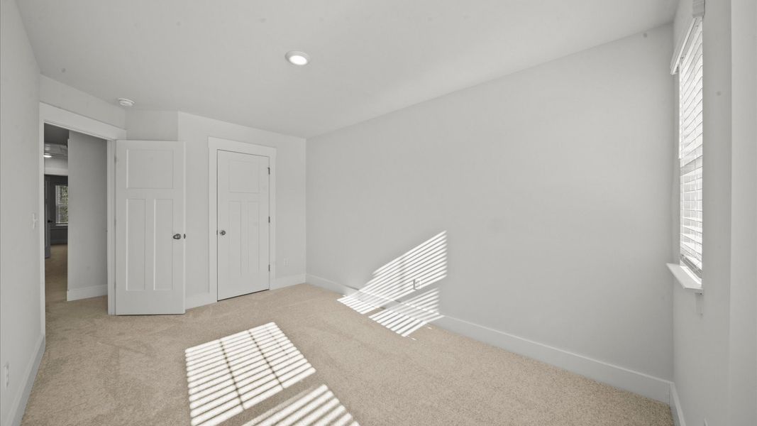 Superior comfort in this light-filled bedroom with plush carpeting and thoughtfully placed large windows