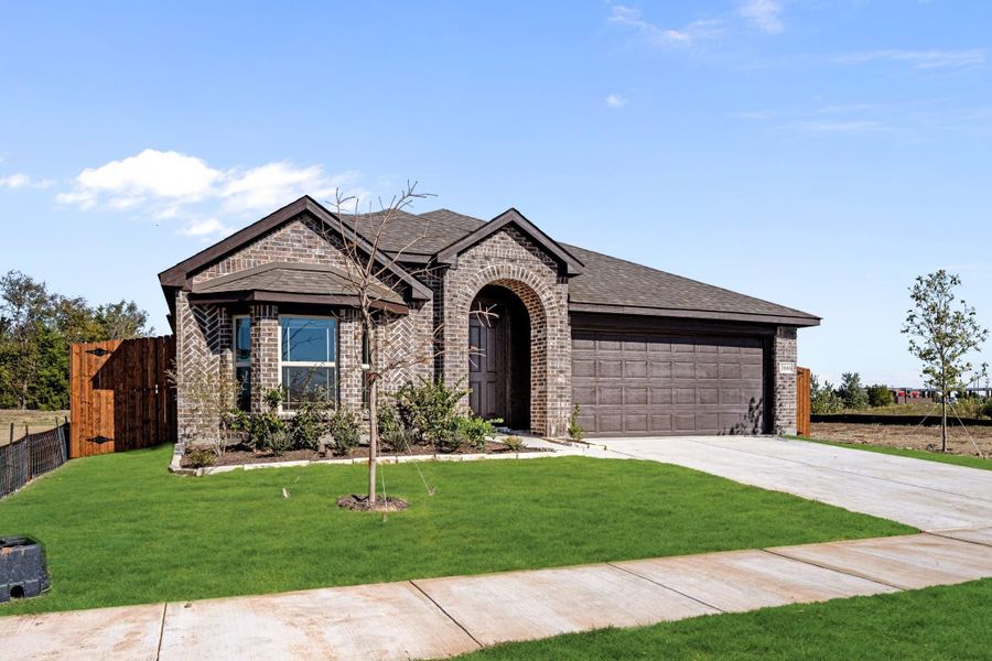 Single-story brick home with arched entry, two-car garage, and green front lawn