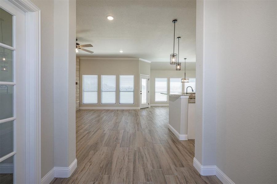 Hall with ornamental molding, sink, and light hardwood / wood-style floors