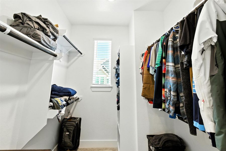 The walk-in closet has a window and plenty of storage space. The walk-in closet has a window and plenty of storage space.