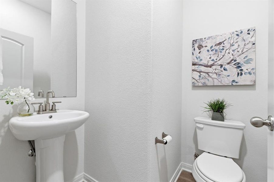 The property features a restroom with a pedestal sink, a toilet, and light-colored walls