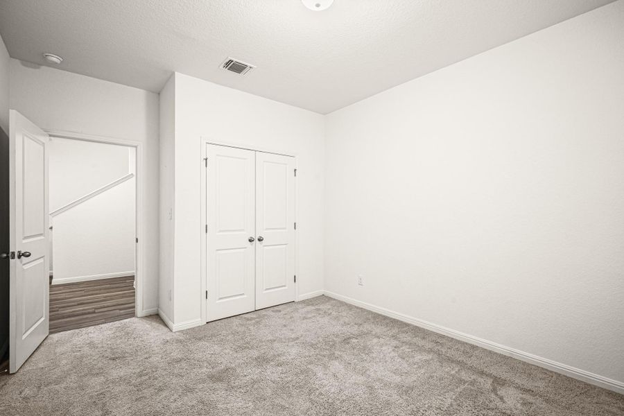 Located downstairs, this bedroom features a textured ceiling and baseboards