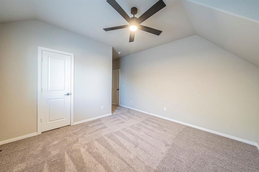 Room featuring a vaulted ceiling and a ceiling fan with integrated lighting